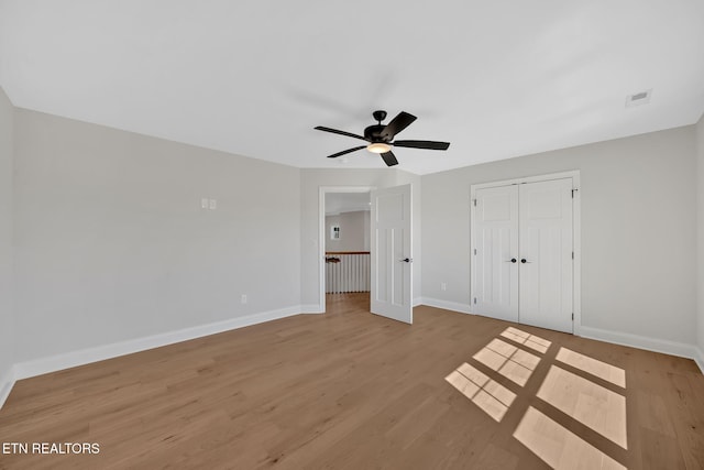 unfurnished bedroom featuring visible vents, a closet, light wood finished floors, baseboards, and ceiling fan