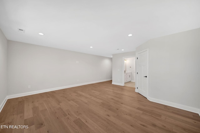 empty room featuring recessed lighting, light wood-style flooring, visible vents, and baseboards