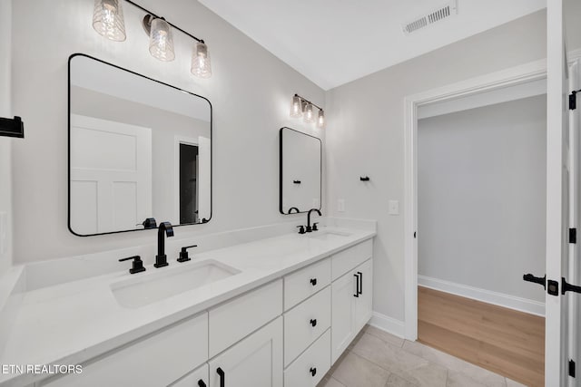 full bathroom with double vanity, visible vents, baseboards, and a sink