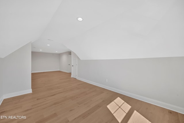 additional living space with recessed lighting, light wood-type flooring, baseboards, and lofted ceiling