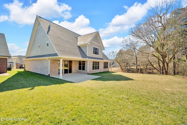 back of house with a yard, a patio area, brick siding, and a shingled roof