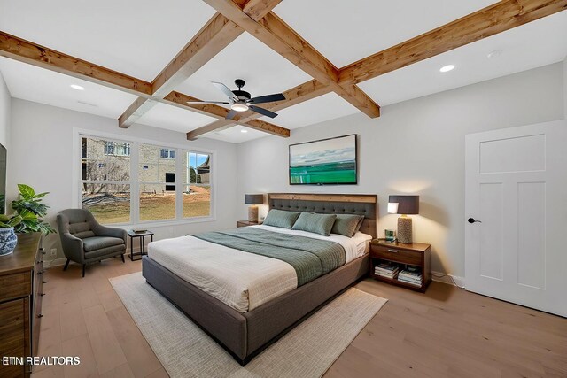 bedroom featuring beam ceiling, coffered ceiling, baseboards, and light wood-style floors