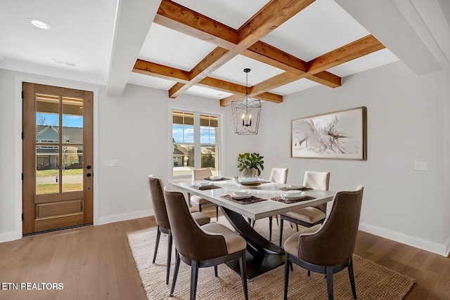 dining space featuring baseboards, coffered ceiling, beam ceiling, and light wood finished floors