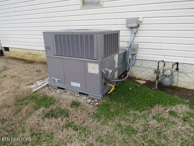 exterior details with gas meter, crawl space, and central AC