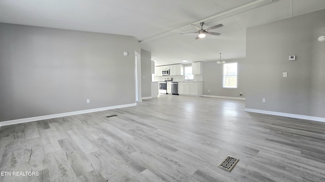 unfurnished living room with sink, ceiling fan with notable chandelier, vaulted ceiling, and light wood-type flooring