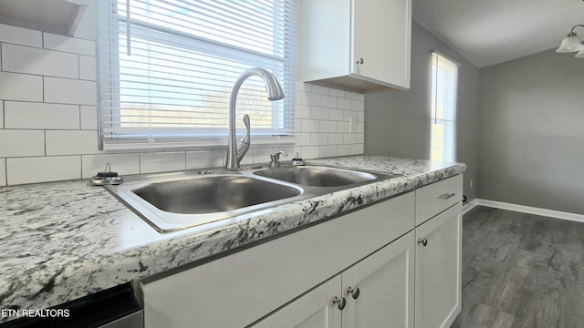 kitchen with lofted ceiling, sink, dark wood-type flooring, tasteful backsplash, and white cabinets