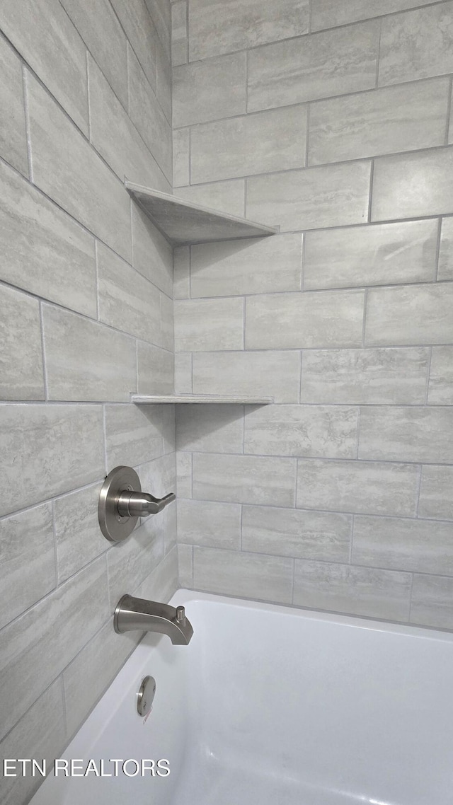 room details with tiled shower / bath combo