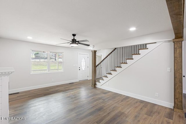 unfurnished living room featuring ceiling fan and dark hardwood / wood-style flooring