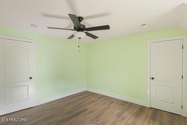 empty room featuring ceiling fan and dark hardwood / wood-style flooring