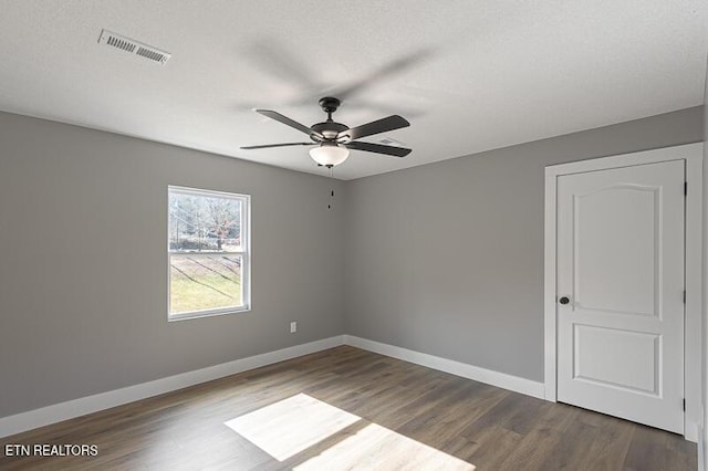 empty room with hardwood / wood-style flooring, a textured ceiling, and ceiling fan