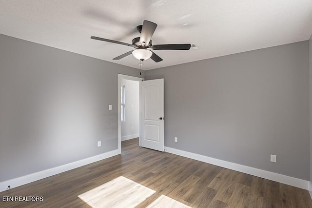 unfurnished room featuring ceiling fan and dark hardwood / wood-style flooring