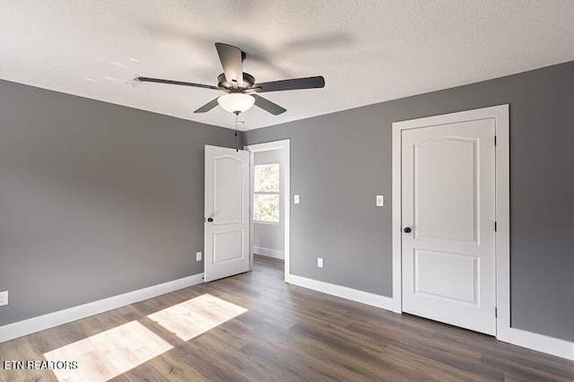 unfurnished bedroom with ceiling fan, dark hardwood / wood-style floors, and a textured ceiling