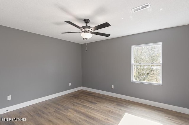 spare room with hardwood / wood-style floors and ceiling fan