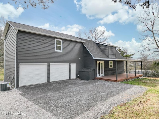 back of property with central AC unit, a garage, and a porch