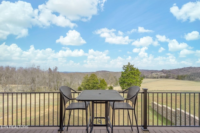 deck featuring outdoor dining space and a lawn