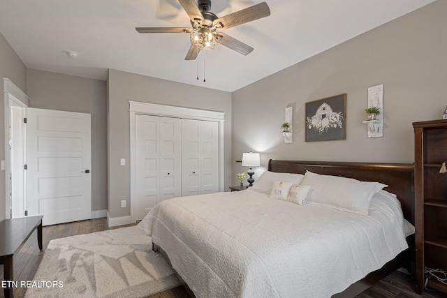 bedroom featuring ceiling fan, dark wood-type flooring, a closet, and baseboards