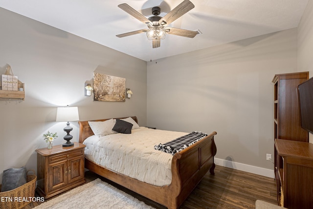 bedroom featuring dark wood-style floors, a ceiling fan, and baseboards