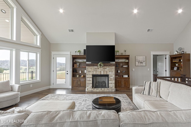 living area featuring baseboards, a fireplace, visible vents, and dark wood finished floors