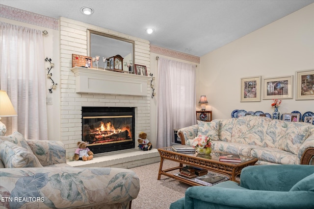 living room featuring a wealth of natural light, lofted ceiling, a fireplace, and a textured ceiling