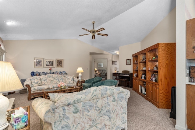 living area featuring ceiling fan, vaulted ceiling, a textured ceiling, and light colored carpet