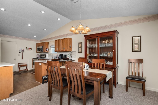 dining area featuring baseboards, lofted ceiling, a textured ceiling, dark carpet, and a notable chandelier