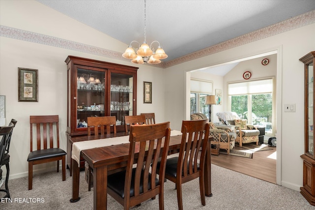 dining room featuring vaulted ceiling, baseboards, light colored carpet, and an inviting chandelier