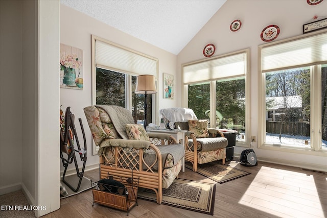 sunroom with visible vents, vaulted ceiling, and a wealth of natural light