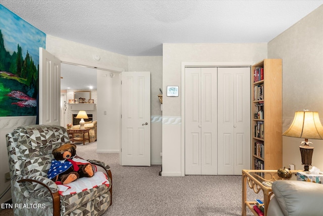 living area with a textured ceiling, carpet, and baseboards