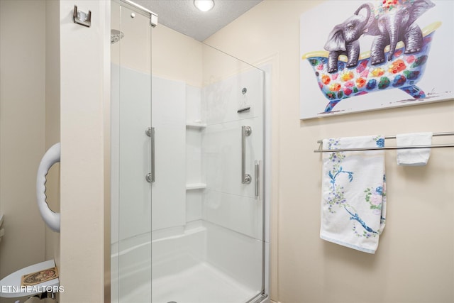 full bathroom with a stall shower and a textured ceiling