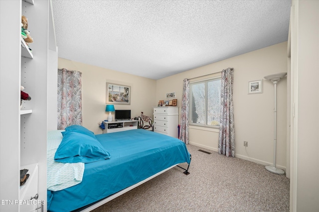 carpeted bedroom featuring visible vents, baseboards, and a textured ceiling