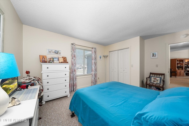 bedroom featuring light carpet, a closet, and a textured ceiling