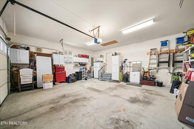 garage with a garage door opener and freestanding refrigerator