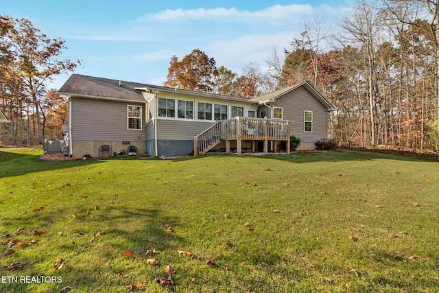 rear view of house featuring a wooden deck, a yard, central AC, and a sunroom