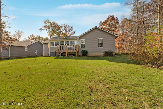 back of house with a lawn and a deck