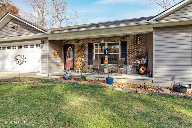 property entrance featuring a yard, a garage, and a porch