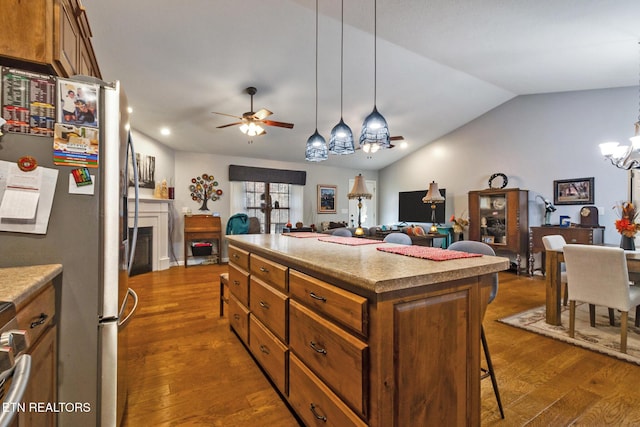 kitchen featuring lofted ceiling, hanging light fixtures, dark hardwood / wood-style floors, and a center island