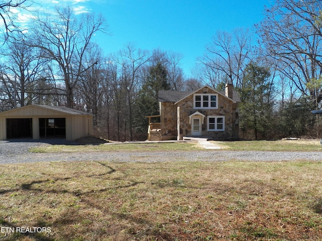 view of front of house with an outdoor structure and a front lawn