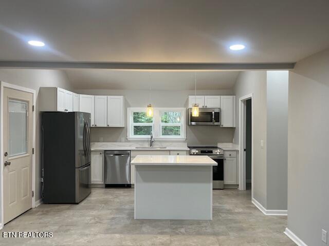 kitchen with white cabinetry, appliances with stainless steel finishes, sink, and hanging light fixtures