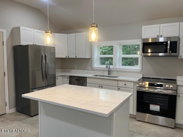 kitchen featuring appliances with stainless steel finishes, a center island, sink, and white cabinets