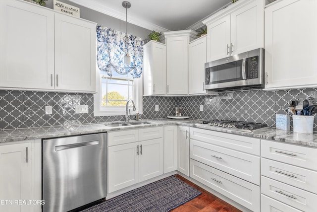 kitchen with sink, white cabinetry, decorative light fixtures, crown molding, and stainless steel appliances