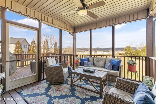 sunroom with ceiling fan, wood ceiling, and a healthy amount of sunlight