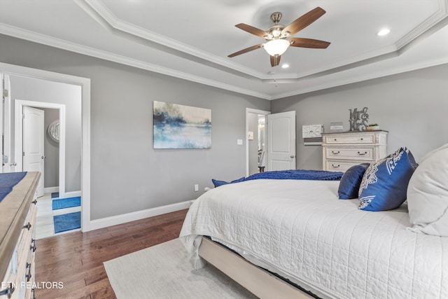 bedroom with ceiling fan, ornamental molding, dark hardwood / wood-style flooring, and a raised ceiling