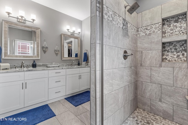 bathroom with a tile shower and vanity