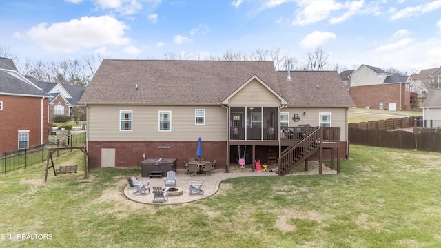 back of house with a hot tub, a patio area, a deck, an outdoor fire pit, and a sunroom