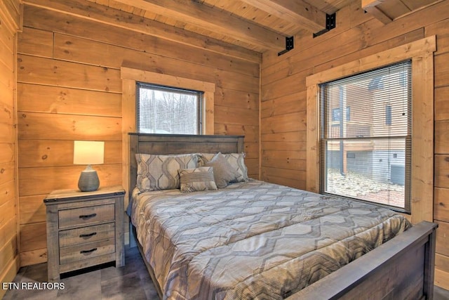 bedroom featuring beamed ceiling, wood ceiling, wooden walls, and multiple windows