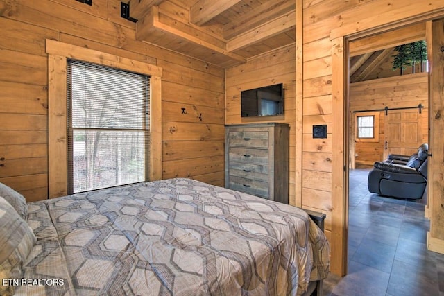 bedroom with wooden walls, a barn door, and beamed ceiling