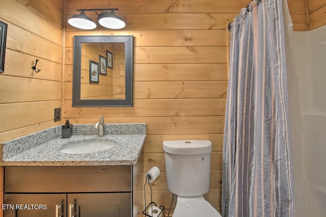 bathroom with vanity, a shower with curtain, toilet, and wood walls