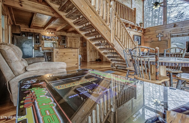living room with ceiling fan and wood walls