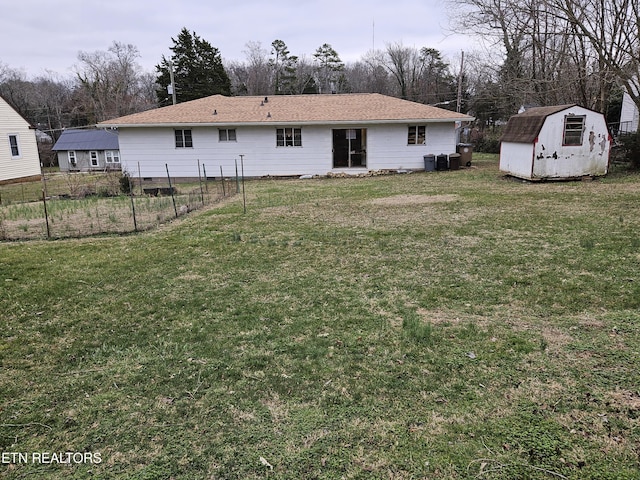 rear view of house with a storage shed and a yard