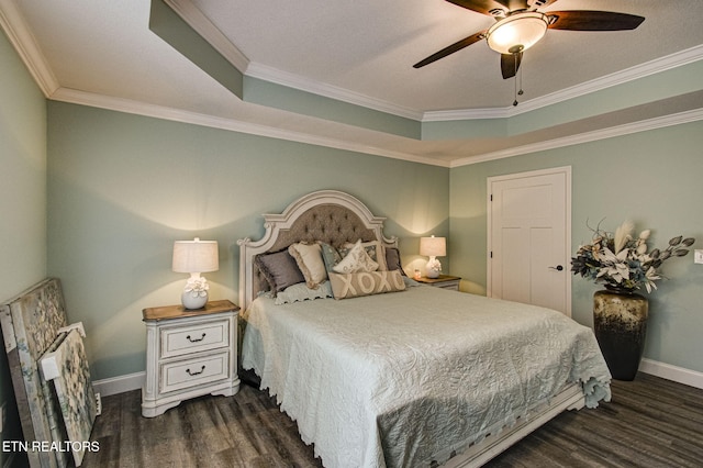 bedroom with crown molding, a tray ceiling, dark hardwood / wood-style floors, and ceiling fan